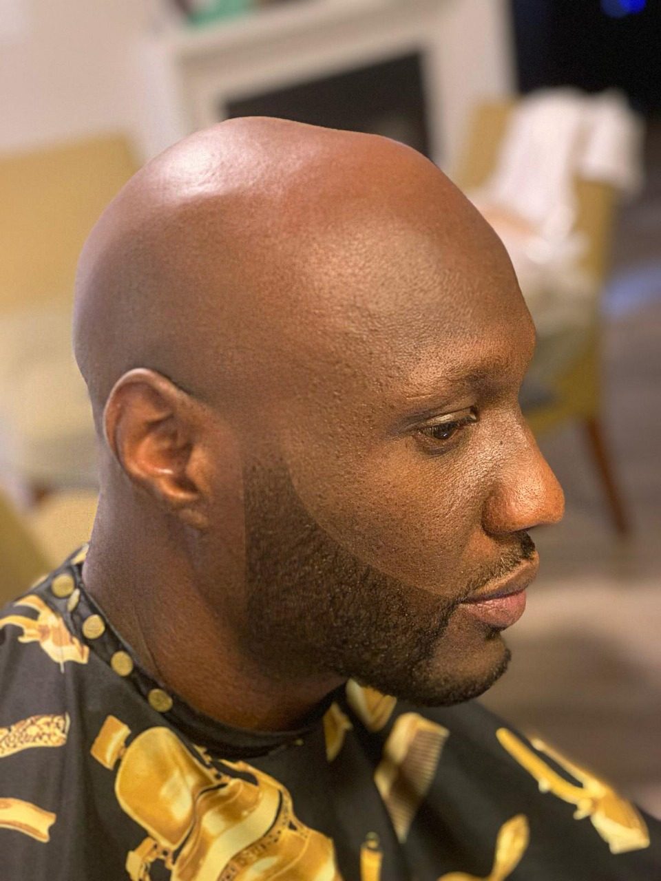 Clean head shave with a shaped beard, cut by Ben Zweifel